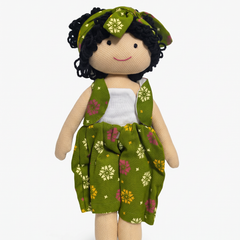A handmade fabric doll with curly black yarn hair, wearing a green floral dress and matching headband over a white top, set against a plain white background.