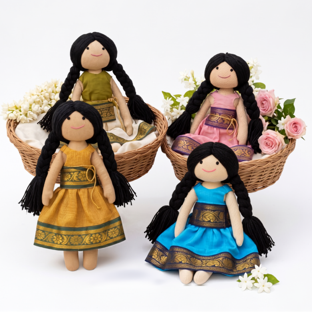 Four dolls with long black hair and traditional outfits in a white setting with flowers.