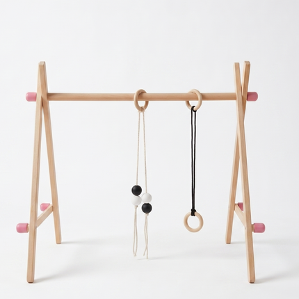 Wooden baby play gym with hanging toys on a white background