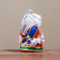 A handmade cloth doll dressed in a traditional Manipuri costume, featuring a Phanek dress, ornaments, and a black belt.